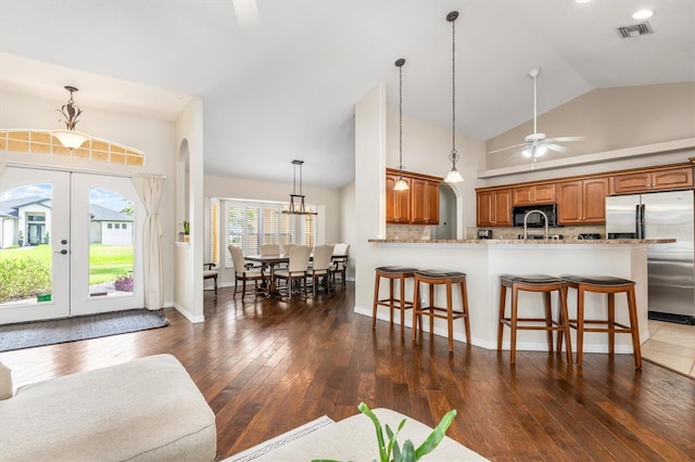 2373 Chartwell Ave, North Port, FL 34288 - kitchen featuring stainless steel fridge, black microwave, a breakfast bar area, a ceiling fan, and dark wood finished floors