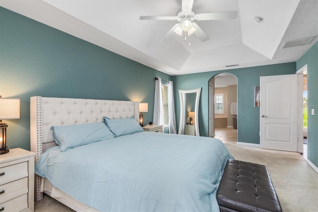 2373 Chartwell Ave, North Port, FL 34288 - carpeted bedroom featuring arched walkways, a raised ceiling, a ceiling fan, and ensuite bath