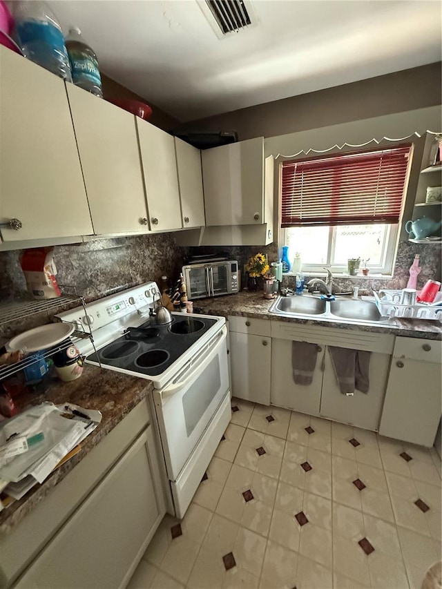 2174 Schwalbe Way, Sarasota, FL 34235 - kitchen with white electric range, a sink, tasteful backsplash, light tile patterned floors, and dark countertops