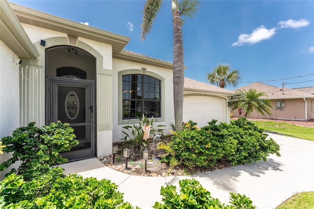 167 Marker Rd, Rotonda West, FL 33947 - view of exterior entry with a garage and stucco siding