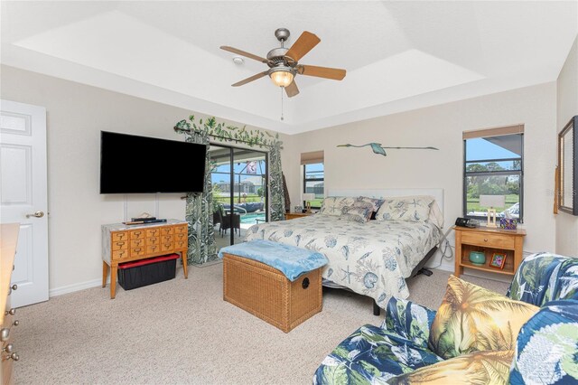 167 Marker Rd, Rotonda West, FL 33947 - bedroom featuring a raised ceiling, multiple windows, carpet floors, and a ceiling fan