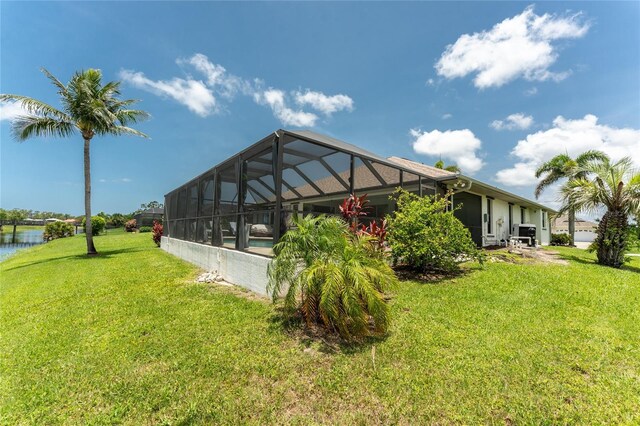 167 Marker Rd, Rotonda West, FL 33947 - rear view of property with a lawn, glass enclosure, and a water view