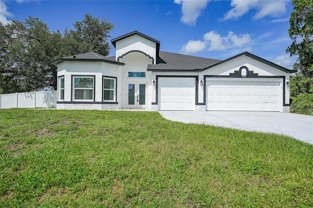 1523 Napoleon Rd, North Port, FL 34288 - view of front of house with french doors, an attached garage, concrete driveway, stucco siding, and a shingled roof