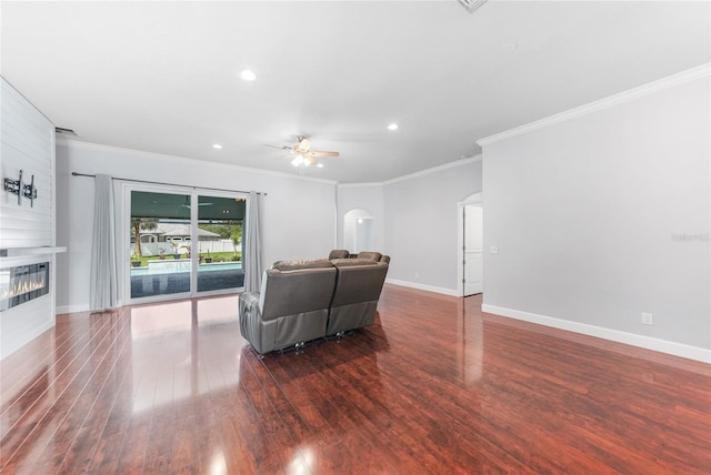 1523 Napoleon Rd, North Port, FL 34288 - living area with a ceiling fan, arched walkways, crown molding, wood finished floors, and a large fireplace