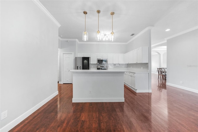 1523 Napoleon Rd, North Port, FL 34288 - kitchen with appliances with stainless steel finishes, white cabinetry, tasteful backsplash, arched walkways, and a kitchen island