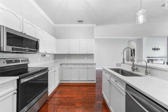 1523 Napoleon Rd, North Port, FL 34288 - kitchen featuring appliances with stainless steel finishes, ornamental molding, light countertops, decorative backsplash, and white cabinets