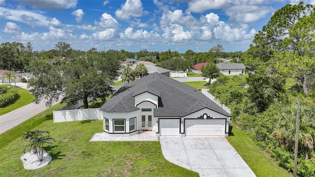 1523 Napoleon Rd, North Port, FL 34288 - view of front of home with a garage, roof with shingles, driveway, stucco siding, and view of wooded area