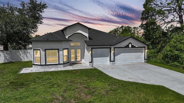 1523 Napoleon Rd, North Port, FL 34288 - view of front of property with stucco siding, driveway, an attached garage, roof with shingles, and french doors