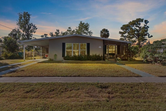 3197 Normandy Dr, Port Charlotte, FL 33952 - view of front facade with a front lawn, stucco siding, driveway, and a carport
