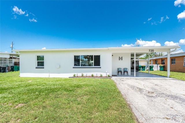 720 Dalton Blvd, Port Charlotte, FL 33952 - view of front of home featuring stucco siding, driveway, an attached carport, and a front yard