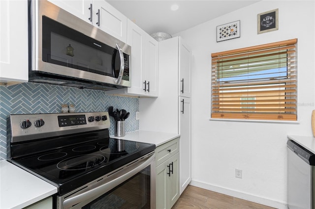 720 Dalton Blvd, Port Charlotte, FL 33952 - kitchen with appliances with stainless steel finishes, decorative backsplash, light countertops, light wood-style flooring, and white cabinets