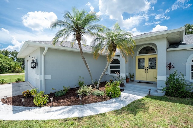 976 Great Falls Ter NW, Port Charlotte, FL 33948 - view of front of home with stucco siding, a front lawn, french doors, and roof with shingles