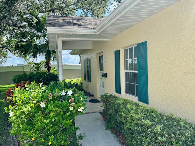1625 Red Oak Ln, Port Charlotte, FL 33948 - view of exterior entry featuring stucco siding and roof with shingles