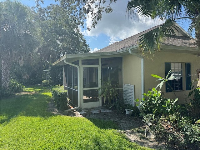 1625 Red Oak Ln, Port Charlotte, FL 33948 - view of side of property featuring stucco siding, a sunroom, a lawn, and roof with shingles