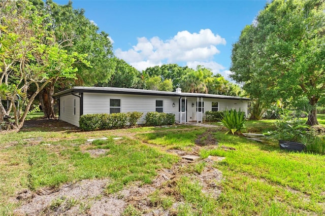 4996 49th St, Vero Beach, FL 32967 - rear view of property with a lawn