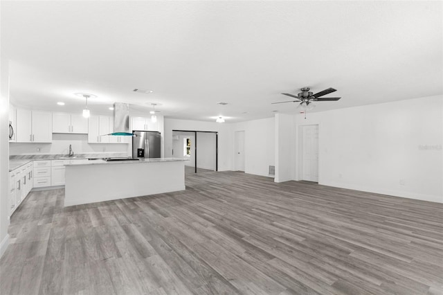 4996 49th St, Vero Beach, FL 32967 - unfurnished living room featuring light wood-type flooring and a ceiling fan