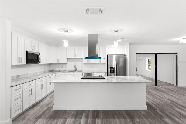 4996 49th St, Vero Beach, FL 32967 - kitchen with stainless steel appliances, wall chimney exhaust hood, a kitchen island, and white cabinets