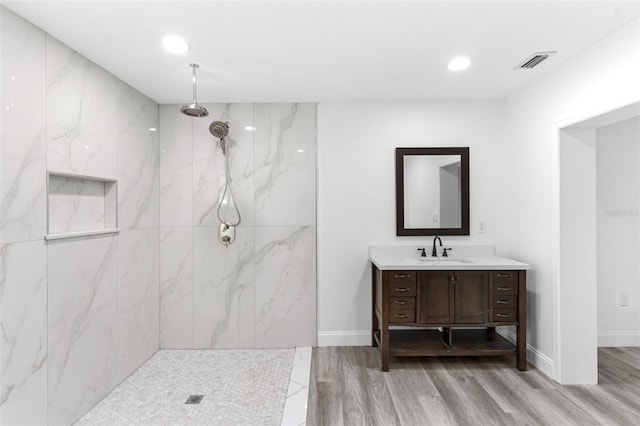 4996 49th St, Vero Beach, FL 32967 - full bath featuring wood finished floors, vanity, a marble finish shower, and recessed lighting