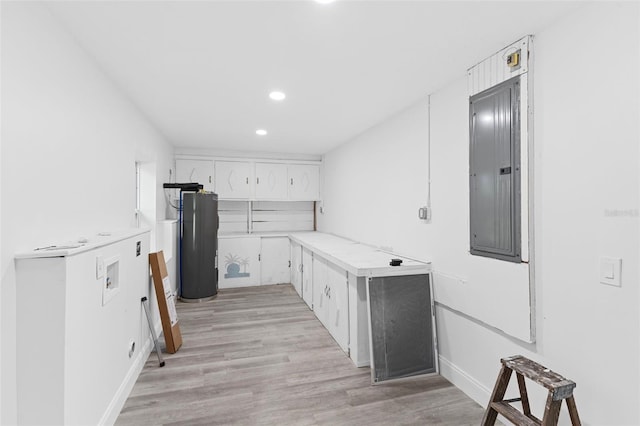 4996 49th St, Vero Beach, FL 32967 - kitchen with water heater, light countertops, electric panel, white cabinets, and recessed lighting