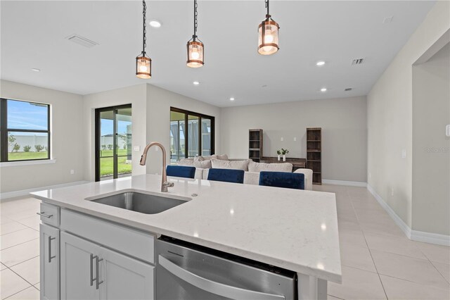 2477 Gabel Oak Dr, North Port, FL 34289 - kitchen featuring stainless steel dishwasher, open floor plan, a center island with sink, light tile patterned flooring, and pendant lighting
