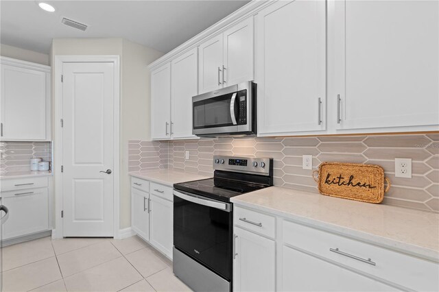 2477 Gabel Oak Dr, North Port, FL 34289 - kitchen with appliances with stainless steel finishes, white cabinets, light tile patterned floors, tasteful backsplash, and recessed lighting
