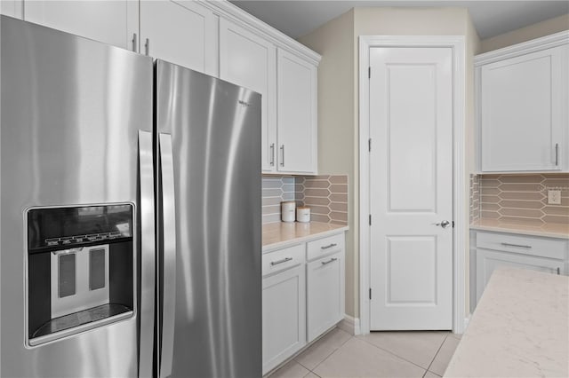 2477 Gabel Oak Dr, North Port, FL 34289 - kitchen featuring stainless steel refrigerator with ice dispenser, white cabinets, tasteful backsplash, and light tile patterned flooring