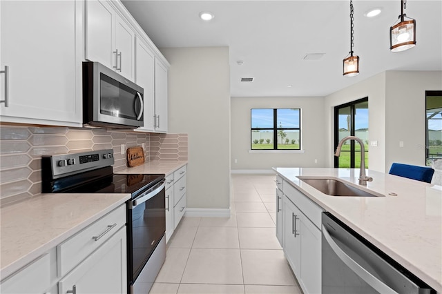 2477 Gabel Oak Dr, North Port, FL 34289 - kitchen with stainless steel appliances, plenty of natural light, decorative backsplash, recessed lighting, and light stone countertops