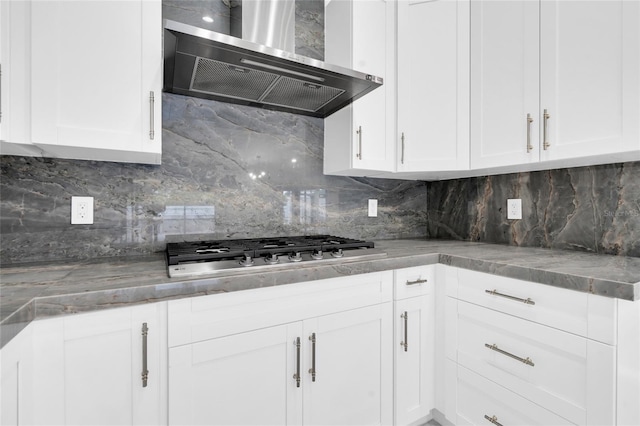 3010 52nd St W, Lehigh Acres, FL 33971 - kitchen with wall chimney exhaust hood, decorative backsplash, white cabinets, and stainless steel gas cooktop