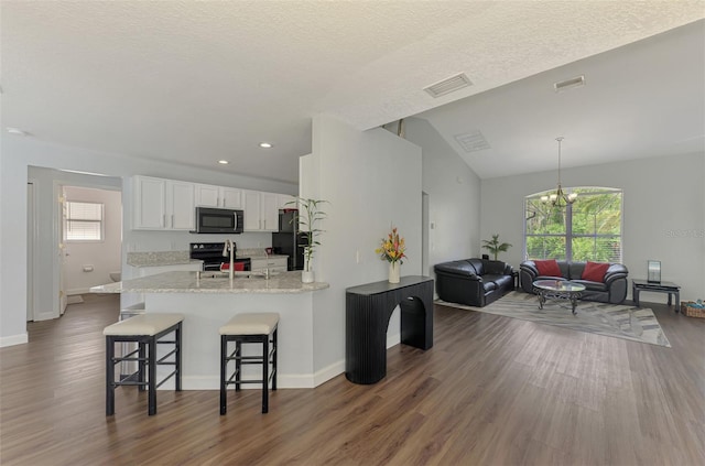 4038 Corydon Ave, North Port, FL 34286 - kitchen featuring freestanding refrigerator, white cabinetry, wood finished floors, a breakfast bar, and recessed lighting