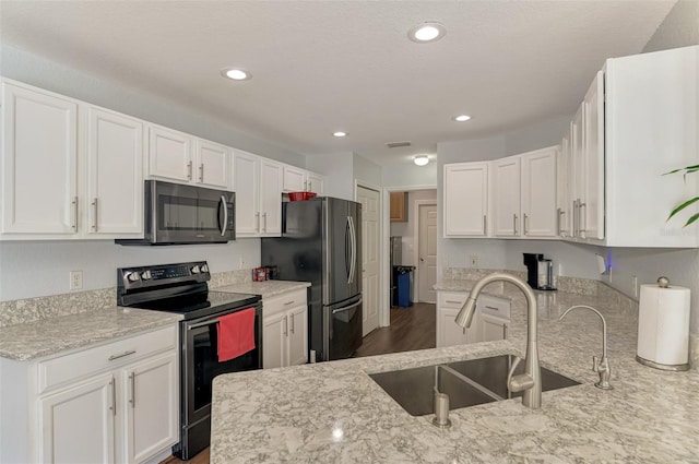 4038 Corydon Ave, North Port, FL 34286 - kitchen featuring appliances with stainless steel finishes, white cabinets, light stone countertops, recessed lighting, and wood finished floors