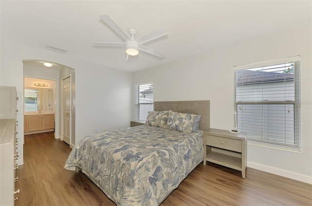 4038 Corydon Ave, North Port, FL 34286 - bedroom featuring wood finished floors, arched walkways, ensuite bathroom, and ceiling fan