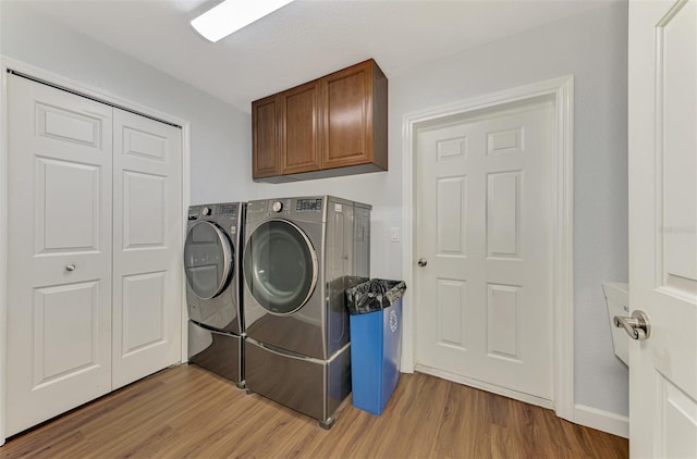 4038 Corydon Ave, North Port, FL 34286 - laundry room featuring washer and clothes dryer, light wood-style flooring, and cabinet space