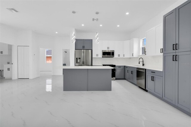 3202 41st St W, Lehigh Acres, FL 33971 - kitchen featuring appliances with stainless steel finishes, plenty of natural light, a center island, light marble finish flooring, and recessed lighting
