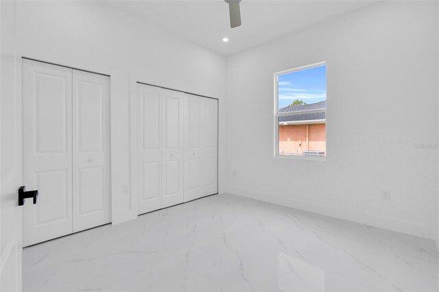 3202 41st St W, Lehigh Acres, FL 33971 - unfurnished bedroom featuring multiple closets, marble look tile flooring, ceiling fan, and recessed lighting