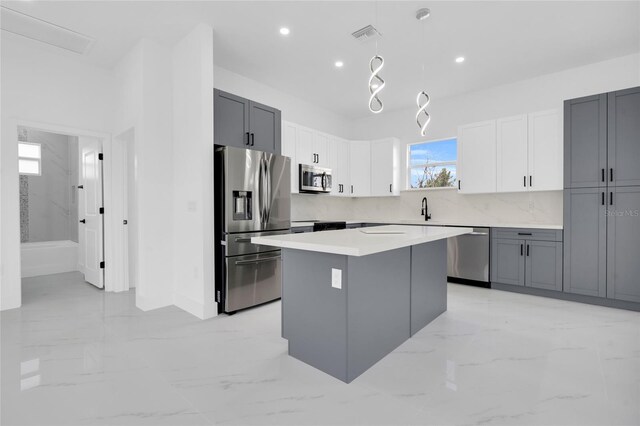 3202 41st St W, Lehigh Acres, FL 33971 - kitchen featuring stainless steel appliances, light marble finish floors, a center island, light countertops, and recessed lighting