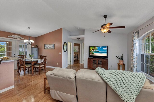 3305 Nansen Ln, North Port, FL 34286 - living area featuring light wood finished floors, lofted ceiling, a ceiling fan, and a chandelier