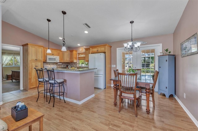 3305 Nansen Ln, North Port, FL 34286 - kitchen with white appliances, healthy amount of natural light, light wood-style floors, a kitchen island, and lofted ceiling