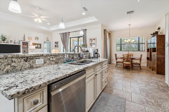 1275 Blue Lake Cir, Punta Gorda, FL 33983 - kitchen with stainless steel dishwasher, a chandelier, a ceiling fan, a raised ceiling, and cream cabinets