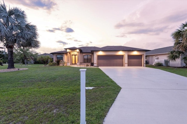 1275 Blue Lake Cir, Punta Gorda, FL 33983 - view of front of house featuring a garage, concrete driveway, stucco siding, and a front lawn