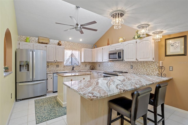25188 Marion Ave Unit 45, Punta Gorda, FL 33950 - kitchen featuring appliances with stainless steel finishes, a peninsula, a ceiling fan, decorative backsplash, and lofted ceiling