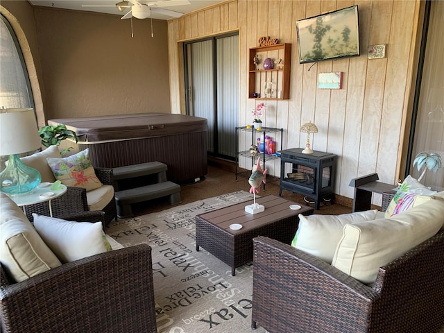21460 Sheldon Ave, Port Charlotte, FL 33952 - carpeted living room with wood walls, ceiling fan, and a wood stove