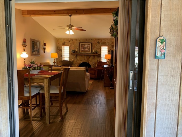 21460 Sheldon Ave, Port Charlotte, FL 33952 - dining room with ceiling fan, beamed ceiling, a stone fireplace, dark wood-style floors, and wallpapered walls
