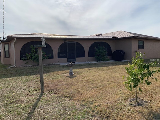 21460 Sheldon Ave, Port Charlotte, FL 33952 - rear view of house with a lawn, stucco siding, a metal roof, and a standing seam roof