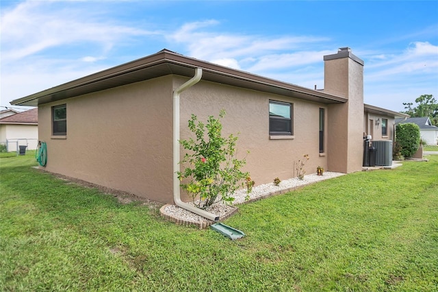 21460 Sheldon Ave, Port Charlotte, FL 33952 - view of property exterior featuring stucco siding, a lawn, and a chimney