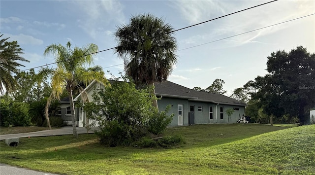 2143 Santonian Ter, North Port, FL 34286 - view of side of property with stucco siding, concrete driveway, and a yard