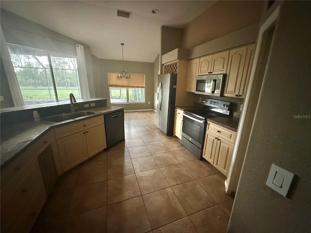 2143 Santonian Ter, North Port, FL 34286 - kitchen featuring appliances with stainless steel finishes, vaulted ceiling, tile patterned floors, decorative light fixtures, and dark countertops