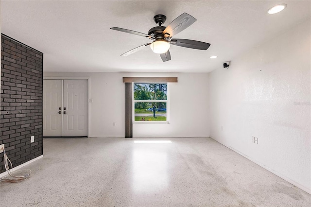 3497 Cohoes St, Port Charlotte, FL 33952 - spare room with ceiling fan, speckled floor, brick wall, and recessed lighting