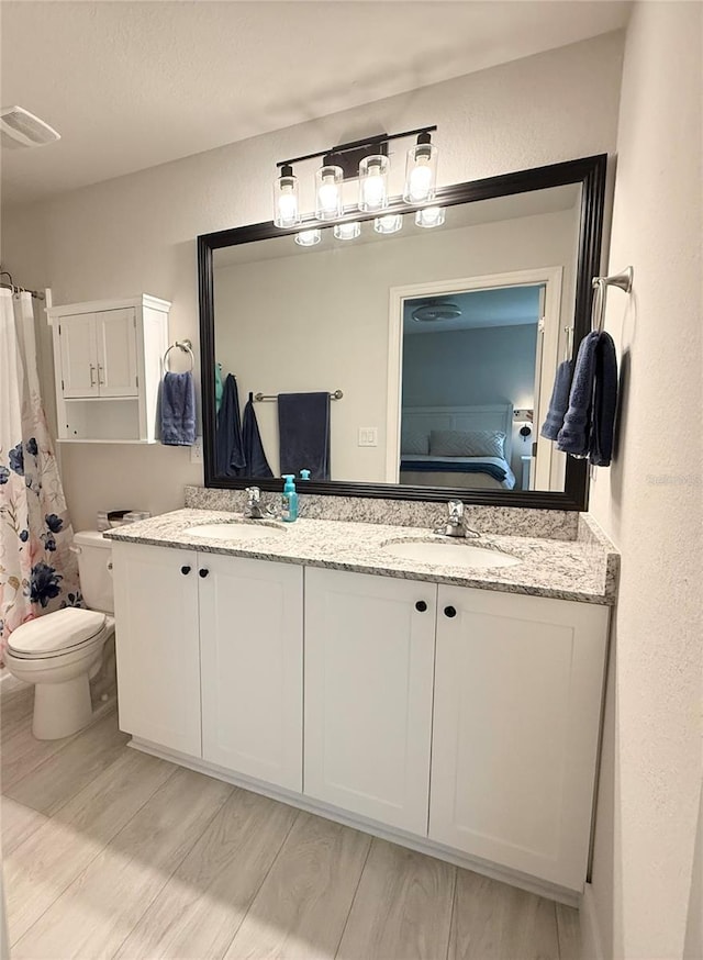 17344 York Ave, Port Charlotte, FL 33948 - ensuite bathroom with double vanity, wood finished floors, and a textured wall