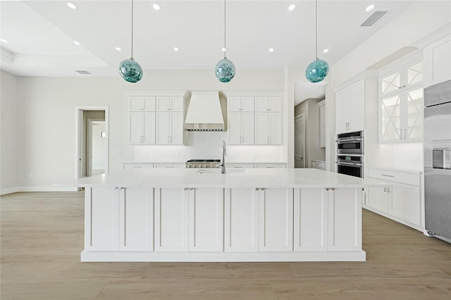2815 Coral Way, Punta Gorda, FL 33950 - kitchen featuring wall chimney exhaust hood, appliances with stainless steel finishes, a spacious island, white cabinets, and recessed lighting