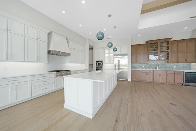 2815 Coral Way, Punta Gorda, FL 33950 - kitchen with stainless steel appliances, premium range hood, beverage cooler, decorative backsplash, and light wood-type flooring